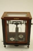 A cased set of scales with scientific glassware  W & J George and Belker