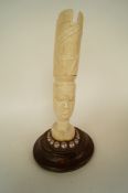 A carved ivory head of an African with pearls and large carved headress