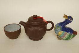 A small tea pot and one cup, together with another item