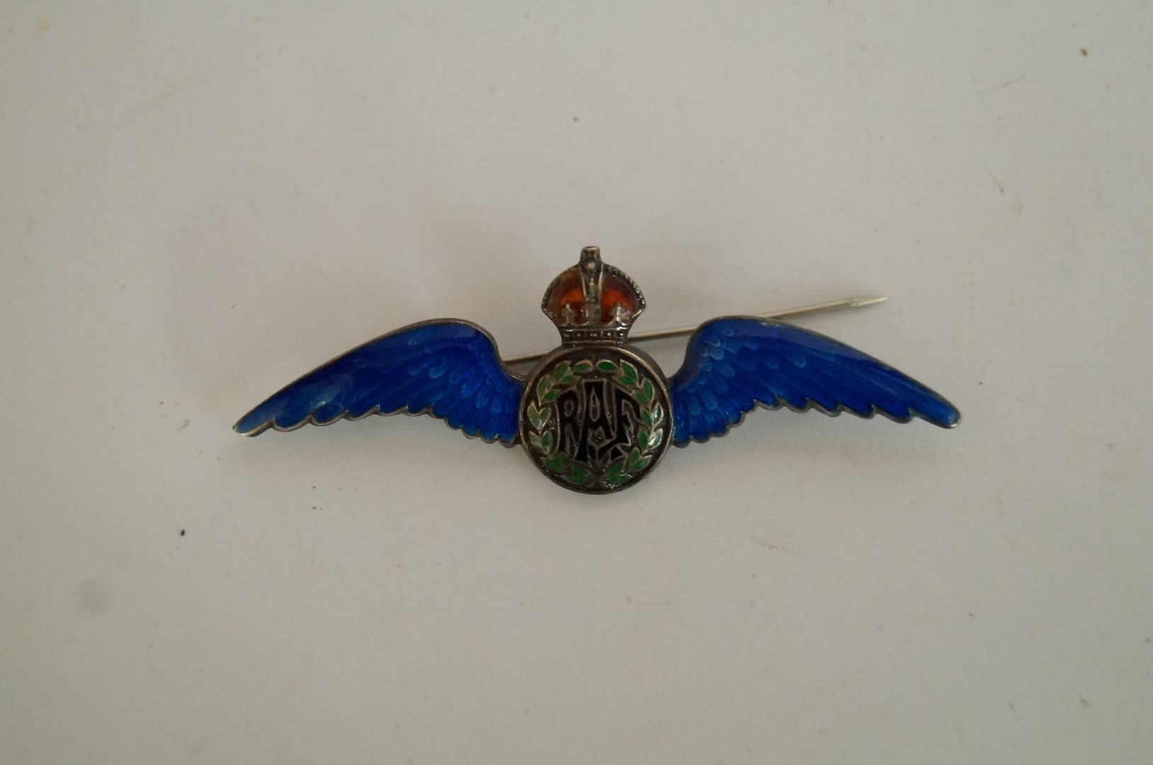 A silver and enamel RAF wings brooch, decorated in blue, black, green and red enamel