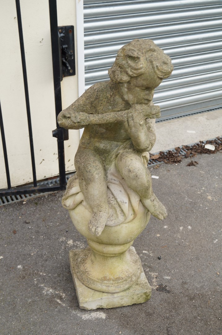 A 20th century stone figure of a cherub playing a piccolo