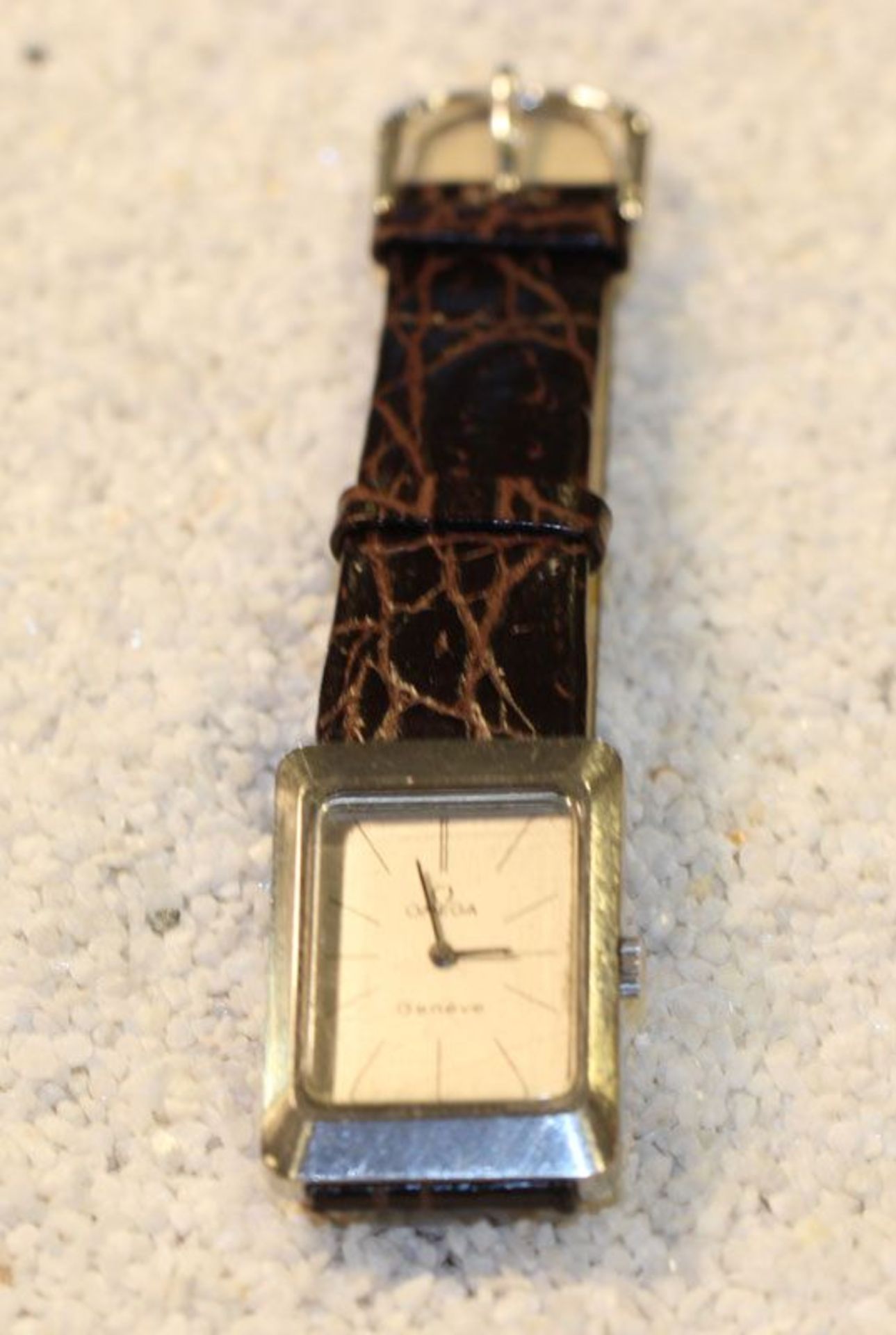 Omega Armbanduhr, Edelstahl Gehäuse mit braunem Lederarmband in Kroko-Optik, getragen