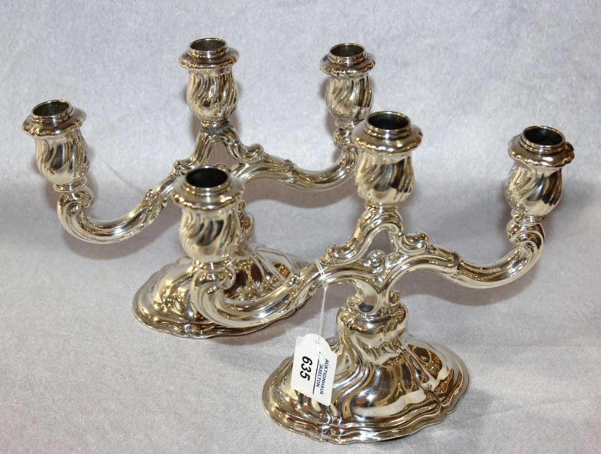Paar Kerzenleuchter in geschwungener Form für je 3 Kerzen, 835 Silber, 1330 gr., gefüllt, H 21 cm, B