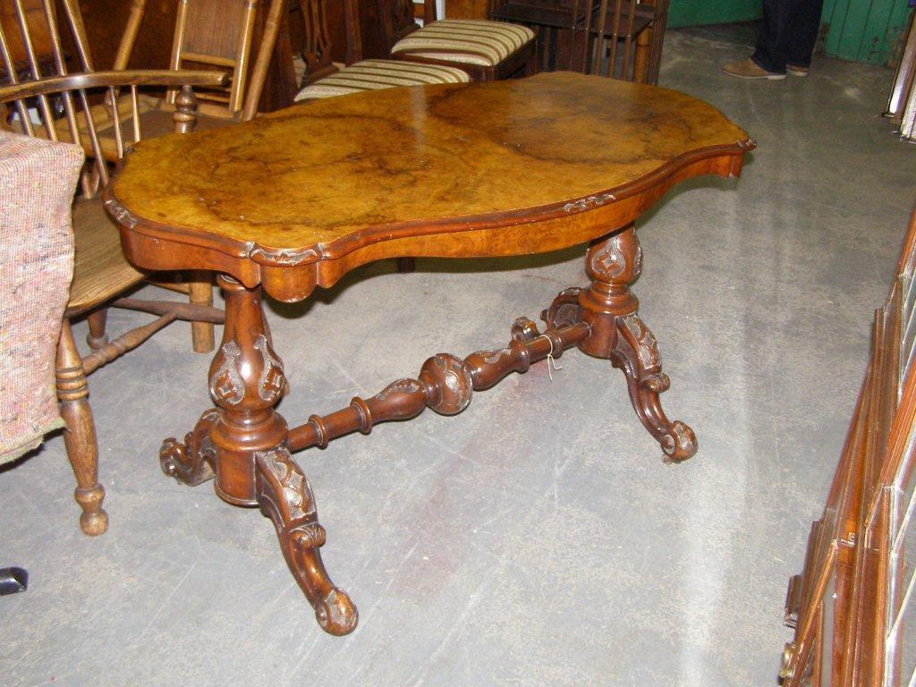 A Victorian walnut stretcher table with serpentine shaped oval top, on baluster end standards