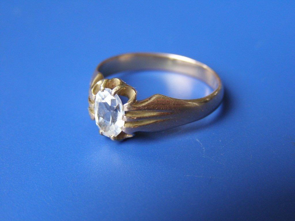 An oval colourless stone solitaire ring in heavy `18c` yellow setting