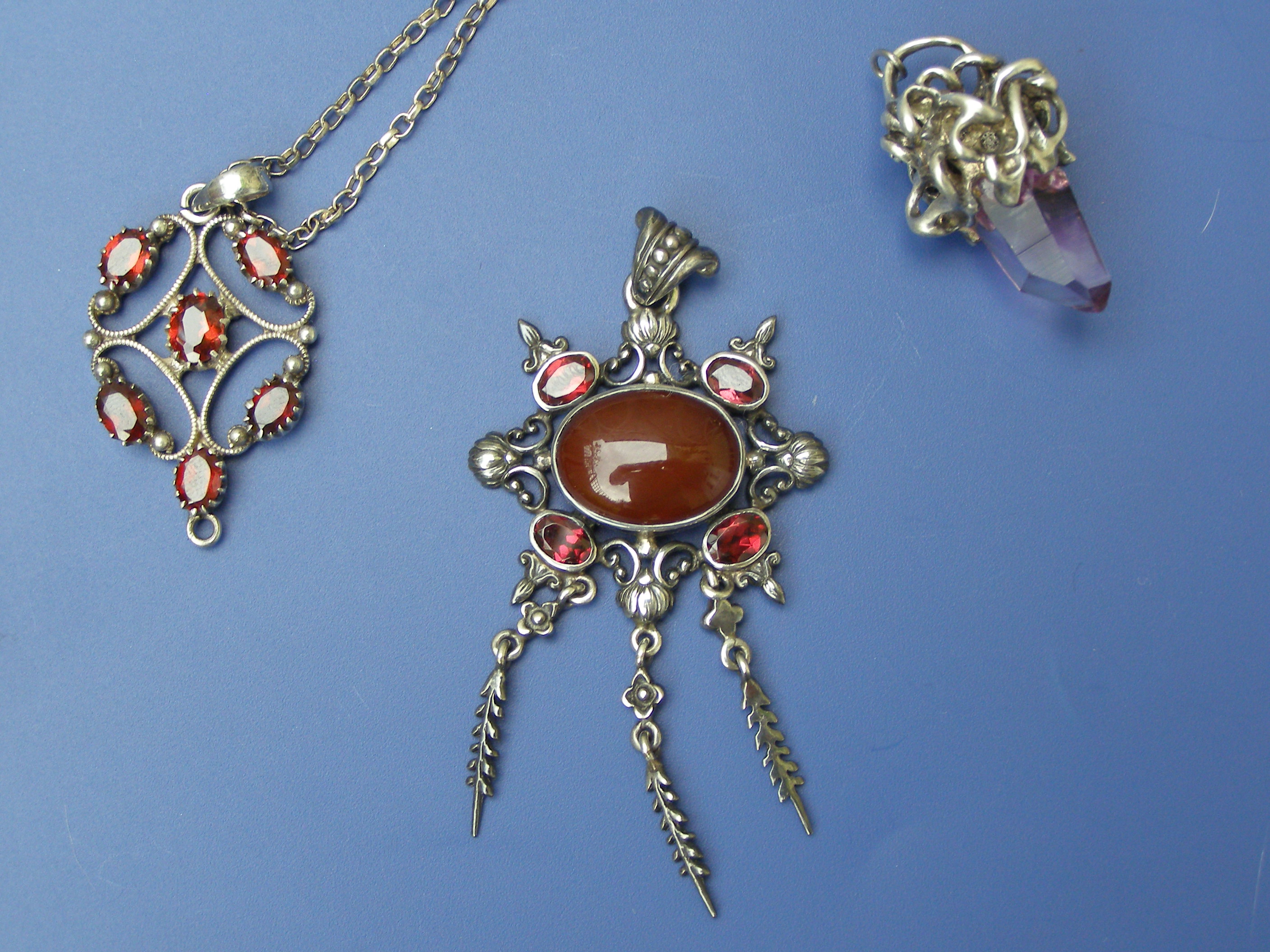 Two garnet pendants and an amethyst white metal designer pendant (3)