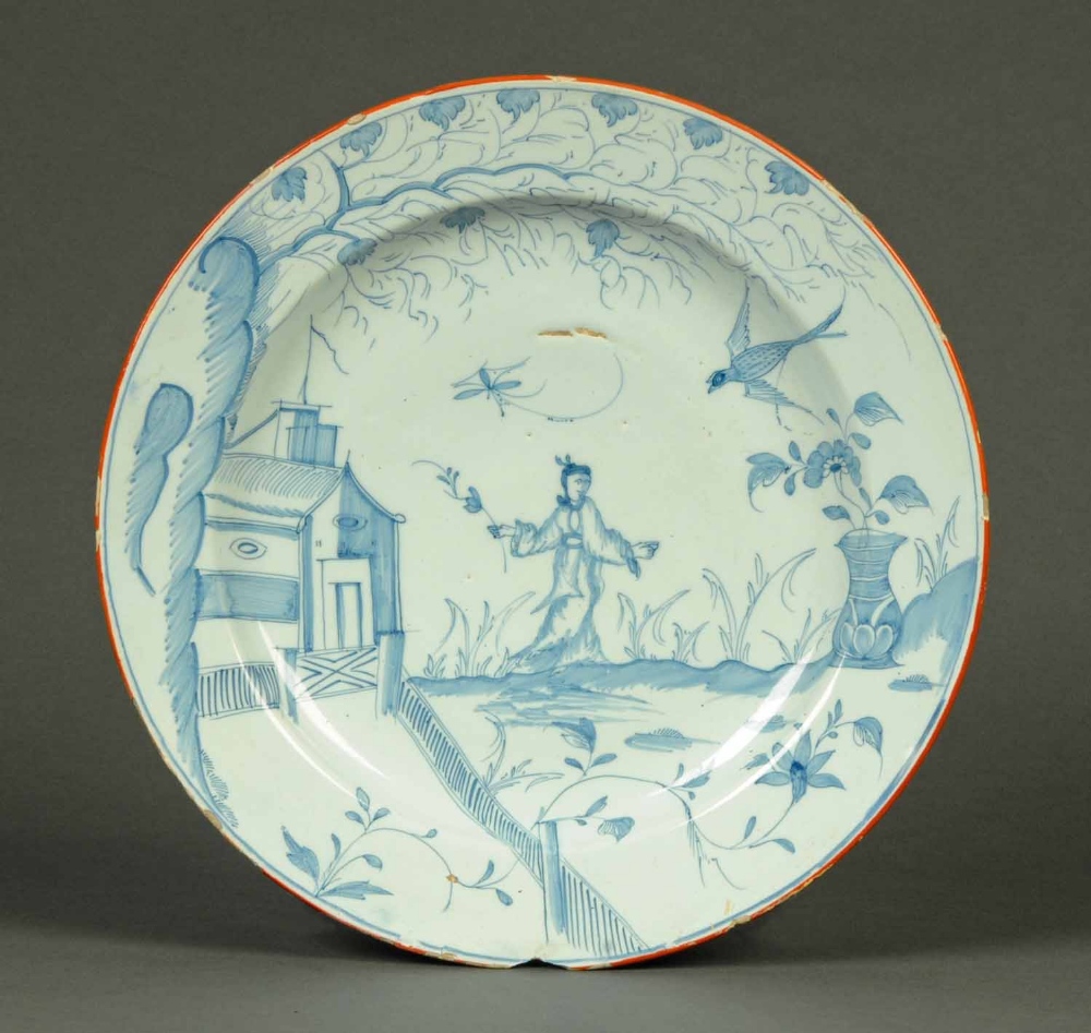 An English Delft charger, circa 1770, with Chinoiserie figure to centre, pheasant, trees,