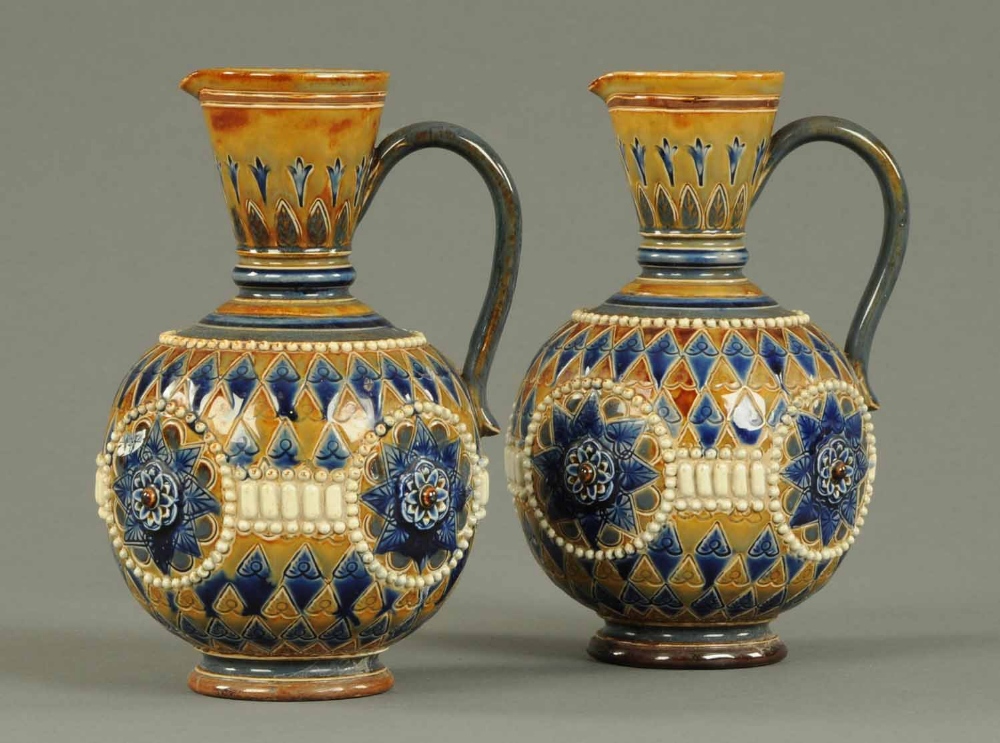 A pair of Doulton Lambeth ewers, decorated in typical colours with impressed marks to base.