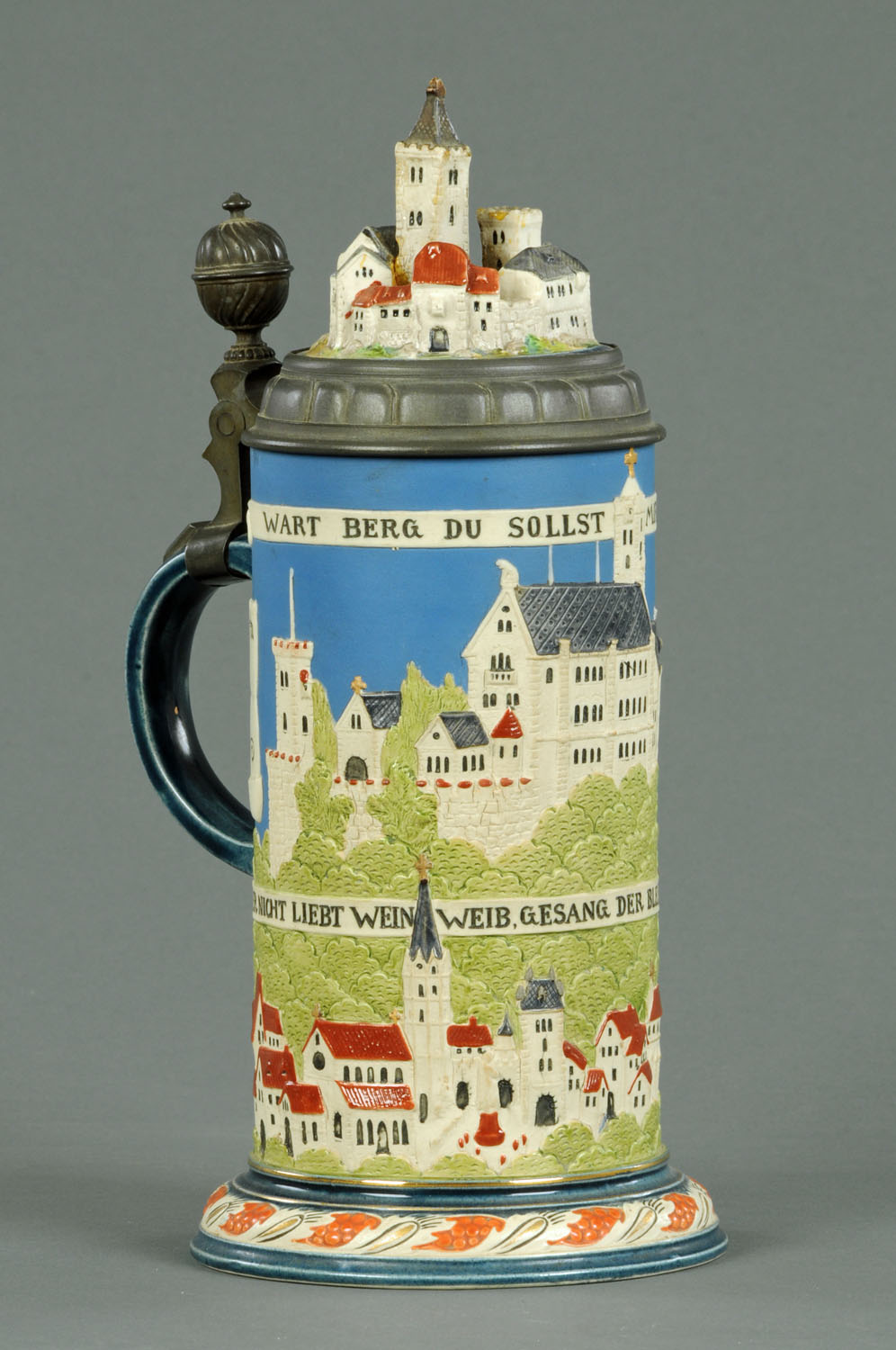 A Mettlach beer stein, with town scenes to pewter lid and body.  Height 31 cm.    CONDITION REPORT: