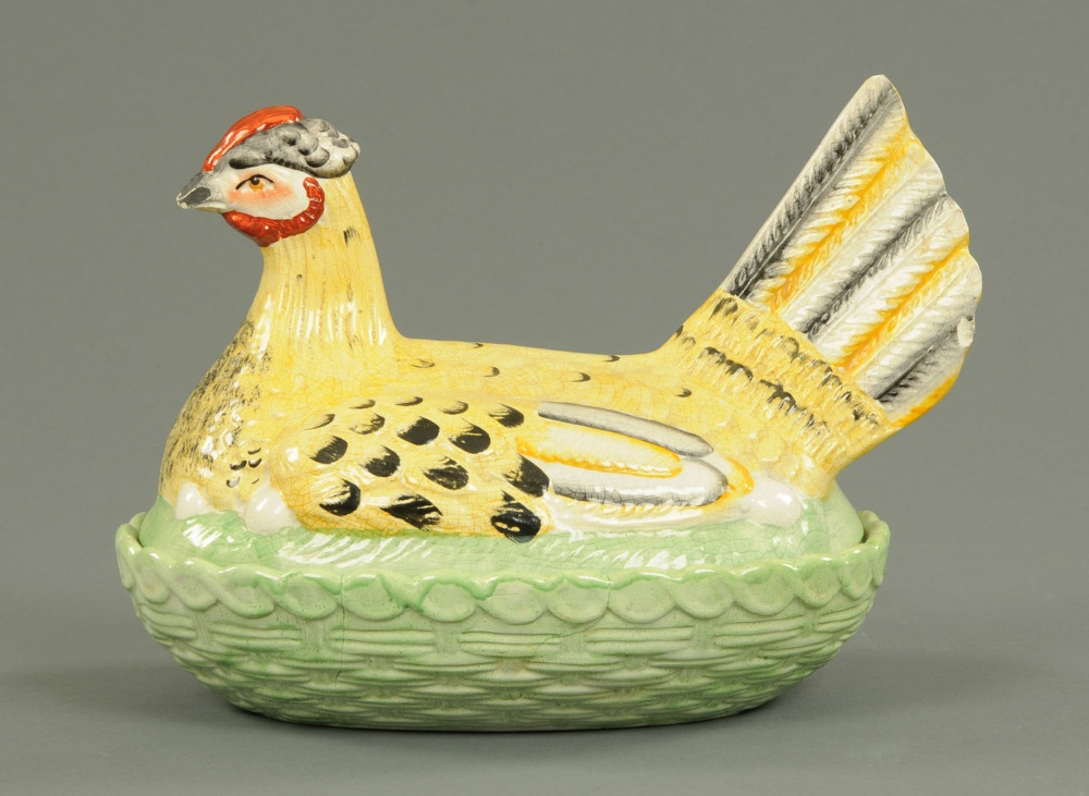 A 19th century Staffordshire egg cruet, in the form of a hen on nest.  Length 13 ins.
