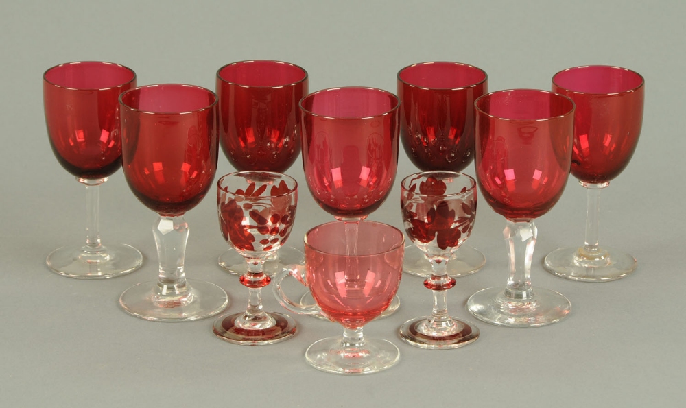 A set of seven cranberry and clear glass wine glasses, custard cup and two other glasses.