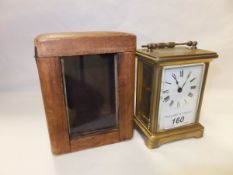 An early 20th Century French lacquered brass cased carriage timepiece, the white porcelain dial with