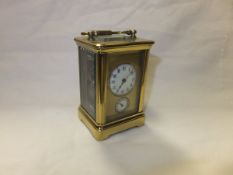 An early 20th Century French lacquered brass cased carriage timepiece, the face with circular