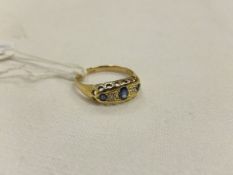 An 18 carat gold ladies dress ring set with three sapphires and two small diamonds