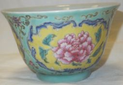 A Chinese porcelain rice bowl decorated with floral cartouches on a yellow ground within celadon and