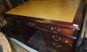 A reproduction mahogany desk, the leather insert top above three frieze drawers to two banks of
