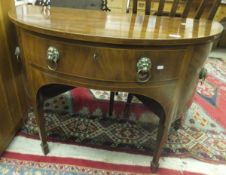 A Regency mahogany demi-lune sideboard with single frieze drawer and cupboard door to either side,