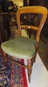 A set of four Victorian dining chairs with shaped stuff-over seat, upholstered in green velvet and