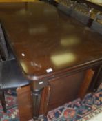 A modern mahogany dining table in the Regency taste, the rounded rectangular top with extra leaf