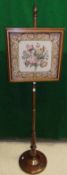 A mahogany pole screen with hand worked wool tapestry with floral decoration