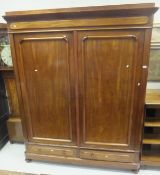 A Victorian mahogany two door wardrobe with two drawers under, on bun feet