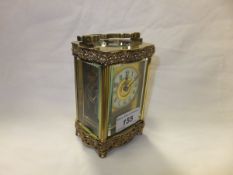 A circa 1900 French lacquered brass cased carriage timepiece, the shaped case with applied scrolling