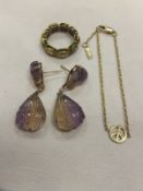 A pair of carved purple and yellow natural stone drop earrings with diamond set hinges, together
