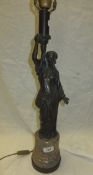 A lamp body in the form of a lady carrying torch, the whole standing on a polished stone and