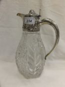 An early 20th Century cut glass claret jug with plated mounts with foliate and scrolling decoration,