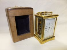 An early 20th Century French lacquered brass cased carriage timepiece, the white porcelain dial with