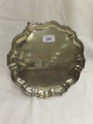 A George V silver serving tray with pie-crust edge, raised on three feet (by Robert Pringle &