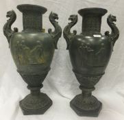 A pair of verdigris style urns in the Greco-Roman style