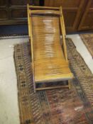 A 1920's stained beech folding deckchair, together with a black painted metal ballot box