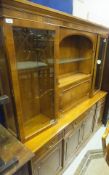 A yew wood display cabinet with glazed doors enclosing three shelves either side of the fall front