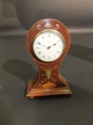 An Edwardian mahogany and inlaid cased balloon clock, the movement with circular dial and Arabic