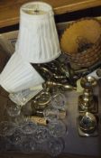A box containing a pair of brass candlesticks, two wall light fittings with brassed finish, a