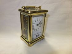 A 20th Century French lacquered brass cased carriage timepiece, the enamelled dial with Roman