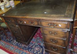 An early mid 20th Century oak desk, the insert top above three frieze drawers and two banks of three