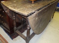 An oval oak gate leg drop leaf dining table in the early 18th Century manner