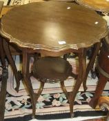 A mahogany pie-crust occasional table on shaped supports united by a central tier