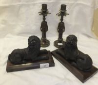 A pair of cast bronze figures of recumbent lions in the 17th Century style and a pair of chocolate