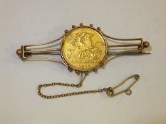 A 1914 half sovereign set in a yellow metal mount as a brooch