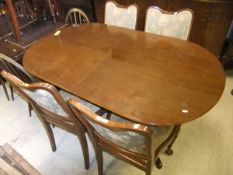 A Strongbow mahogany extending dining table and four chairs with foliate upholstery and a matching