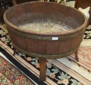 An oak oval coopered barrel style planter on splayed supports
