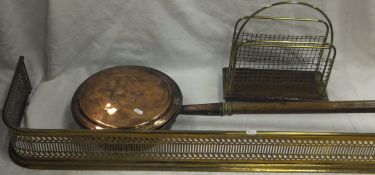 A brass fire kerb, a brass newspaper rack and a copper bed warming pan