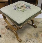 A 19th Century mahogany framed footstool with X framed ends over a central stretcher with tapestry