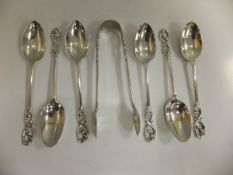 A set of six George V silver teaspoons with scrolling foliate finials, together with a pair of