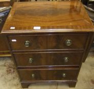 A reproduction mahogany small chest of three long drawers on bracket feet