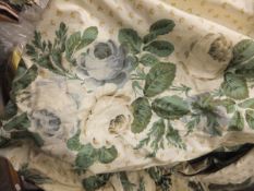 A pair of glazed cotton interlined curtains, the cream ground with green and blue floral sprays,