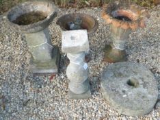 A natural stone grind stone, two terracotta urns, a reconstituted stone bird bath with circular top,
